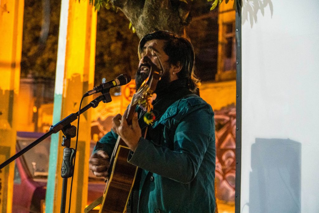Musico Luchin, interpreta con una guitarra acustica canciones para el publico, previo a la muestra de cortometrajes.